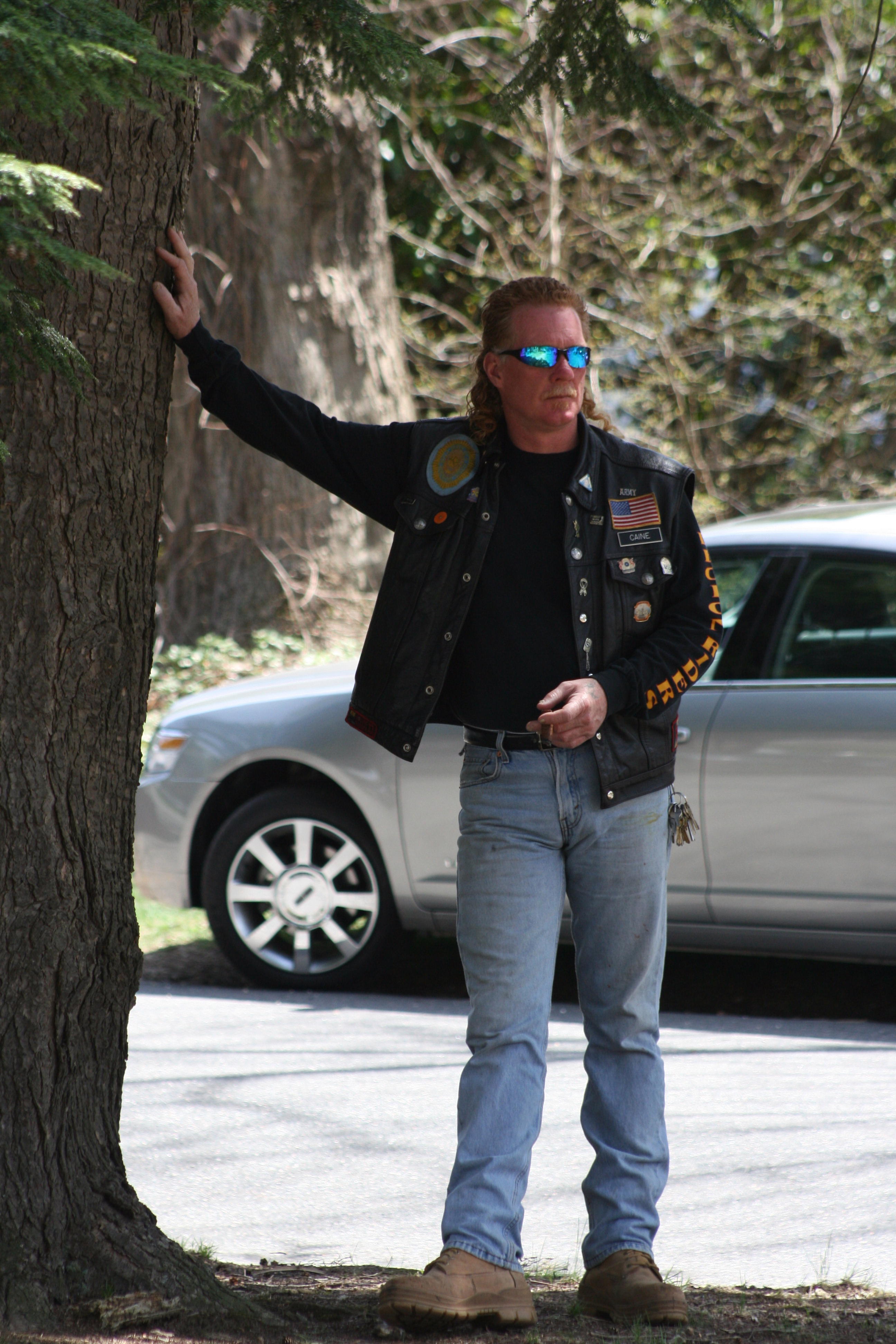 Veteran leaning against a tree
